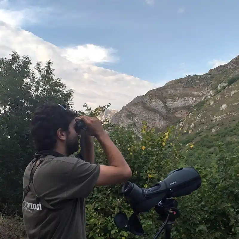Gonzalo con unos primaticos observando aves.